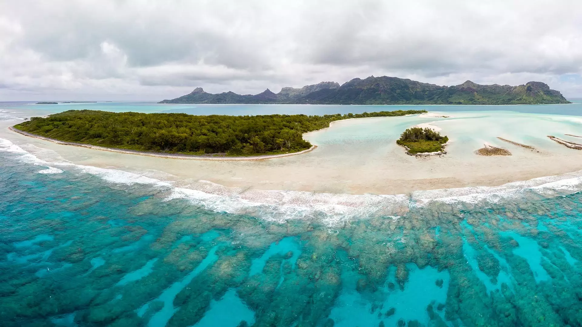 Luftsicht auf die Insel Raivavae mit Sandstränden, Korallenriff und grünen Inselchen in einer hellblauen Lagune